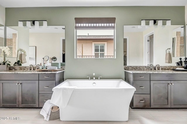 bathroom with tile patterned flooring, vanity, and a bathtub