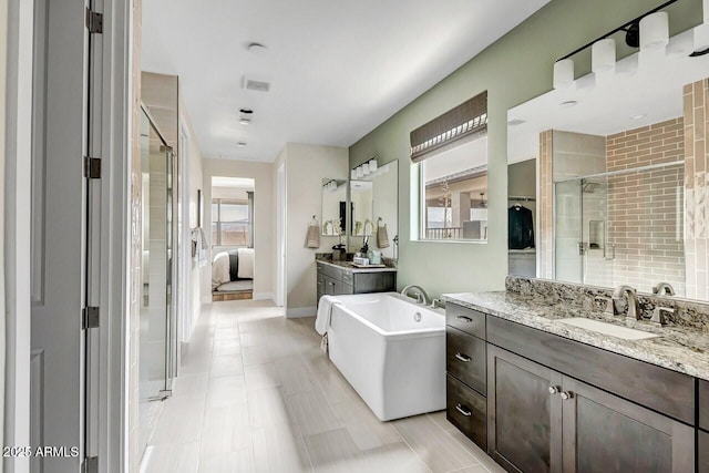 bathroom featuring vanity and independent shower and bath