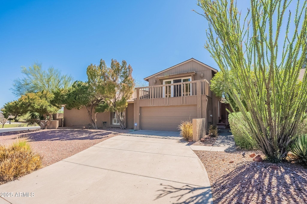 view of front of house with a garage, concrete driveway, and stucco siding