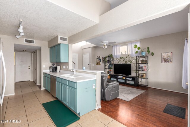 kitchen featuring ceiling fan, dishwasher, light hardwood / wood-style floors, and a textured ceiling