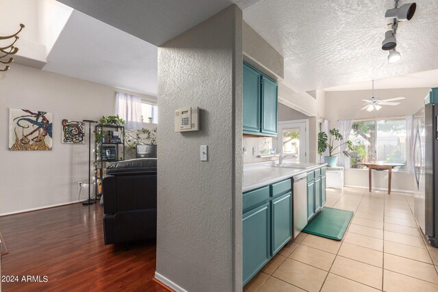 kitchen with plenty of natural light, lofted ceiling, a textured ceiling, and light hardwood / wood-style flooring