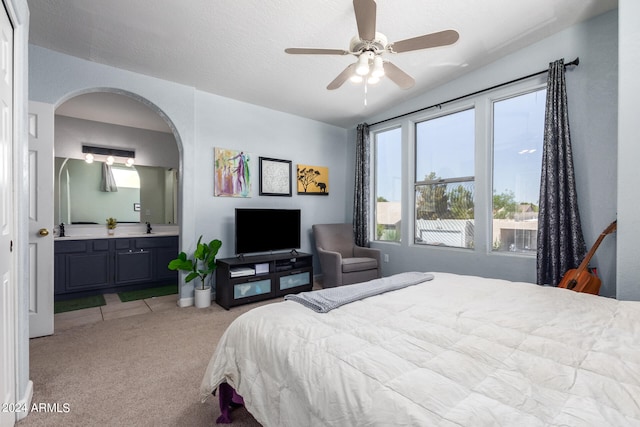 carpeted bedroom featuring ceiling fan, ensuite bathroom, and a textured ceiling