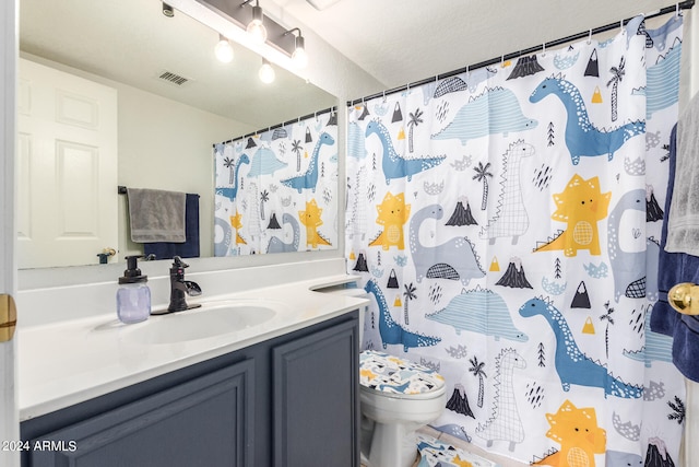 bathroom with vanity, curtained shower, toilet, and a textured ceiling