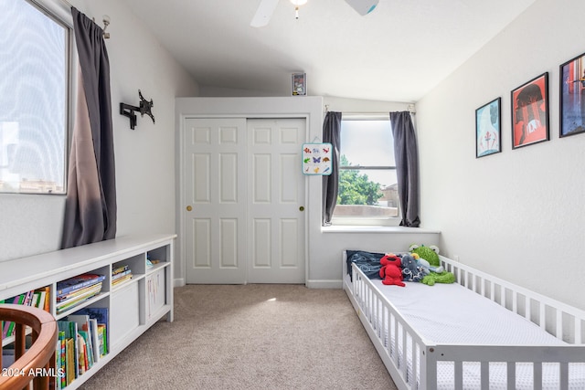 bedroom featuring a closet, vaulted ceiling, ceiling fan, and light colored carpet