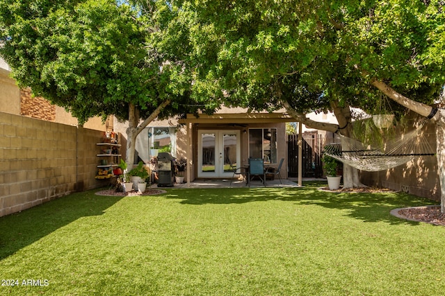 back of house with french doors and a yard