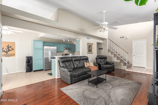 living room with light hardwood / wood-style floors, track lighting, and ceiling fan