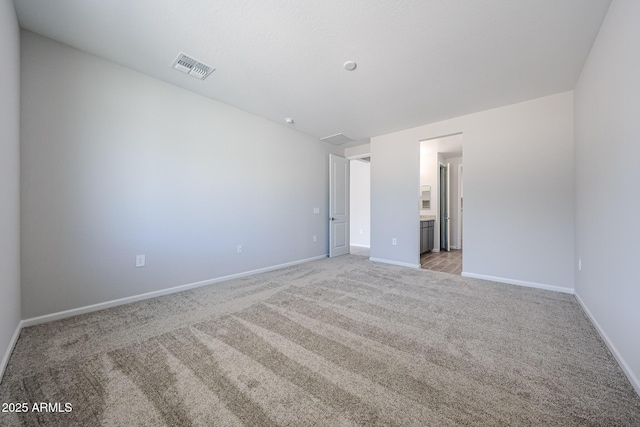 17716 W Fulton St, Goodyear, AZ 85338 - unfurnished bedroom featuring baseboards, light colored carpet, ensuite bathroom, and visible vents