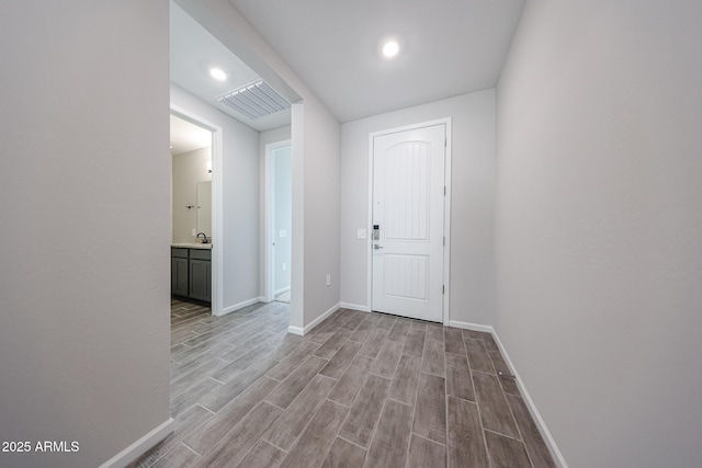 17716 W Fulton St, Goodyear, AZ 85338 - hallway featuring a sink, light wood-style flooring, recessed lighting, baseboards, and visible vents