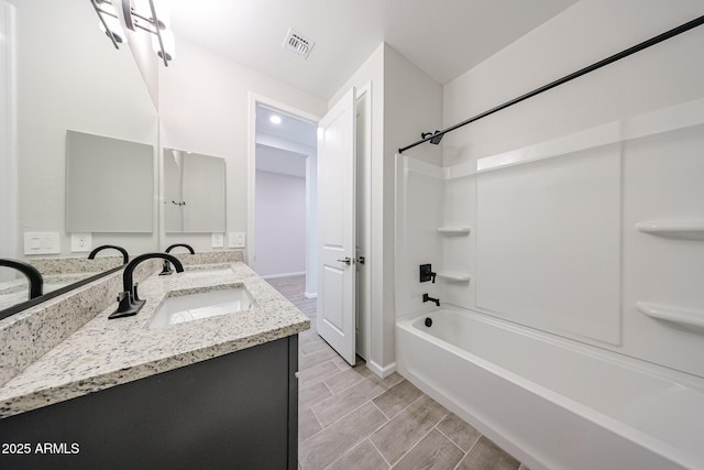 17716 W Fulton St, Goodyear, AZ 85338 - bathroom featuring visible vents, wood finish floors, vanity, baseboards, and  shower combination