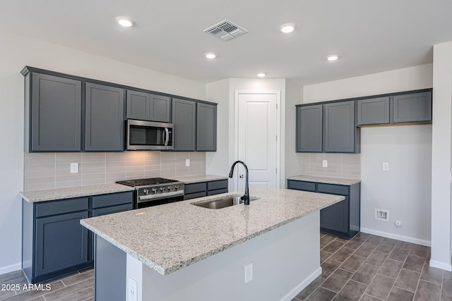 17716 W Fulton St, Goodyear, AZ 85338 - kitchen featuring visible vents, light stone counters, a sink, appliances with stainless steel finishes, and backsplash