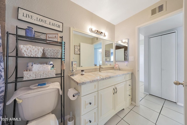 bathroom featuring toilet, vanity, tile patterned flooring, and visible vents