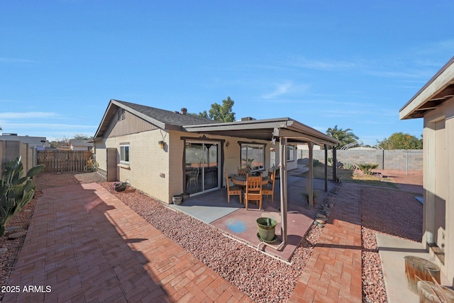 rear view of house with a patio area, a fenced backyard, and brick siding