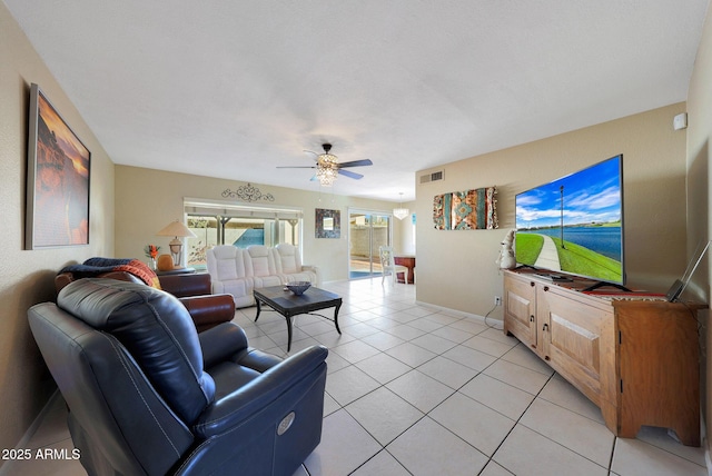 living room with light tile patterned floors, visible vents, baseboards, and a ceiling fan