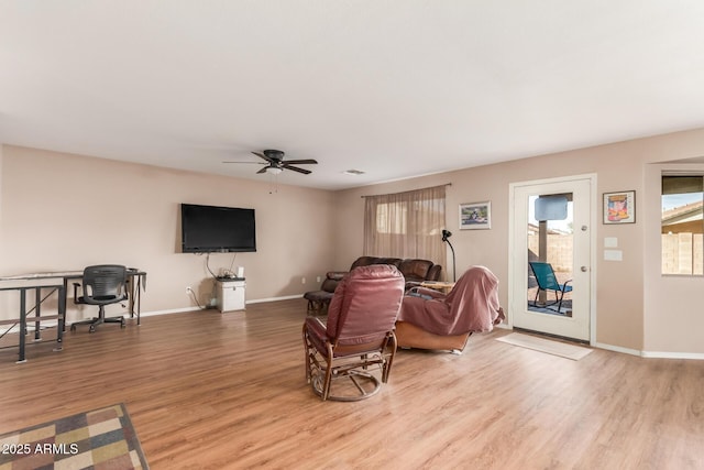 living area featuring ceiling fan, baseboards, and wood finished floors