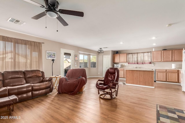 living area featuring visible vents, baseboards, light wood-type flooring, recessed lighting, and a ceiling fan