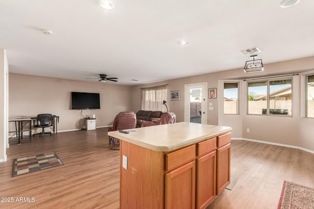 kitchen featuring a center island, visible vents, light countertops, and light wood-type flooring