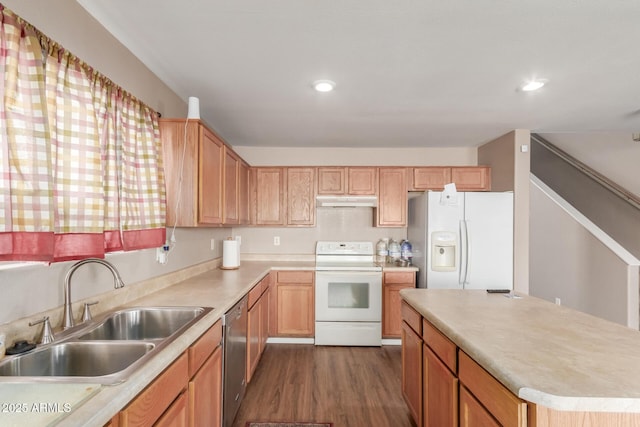 kitchen featuring white appliances, a sink, light countertops, dark wood-type flooring, and under cabinet range hood