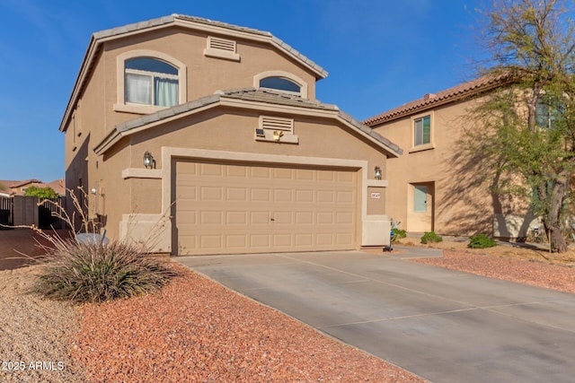 mediterranean / spanish-style home with a tile roof, stucco siding, an attached garage, and concrete driveway