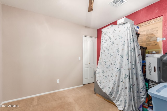 bedroom with visible vents, baseboards, ceiling fan, light colored carpet, and a closet