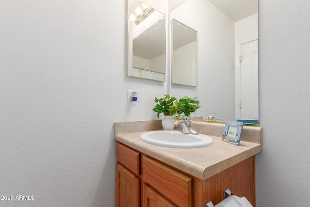 bathroom with vanity and a textured wall