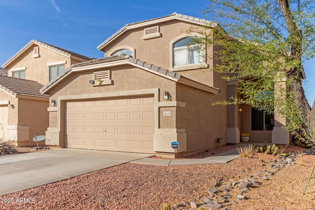 mediterranean / spanish-style house with a tiled roof, driveway, and stucco siding