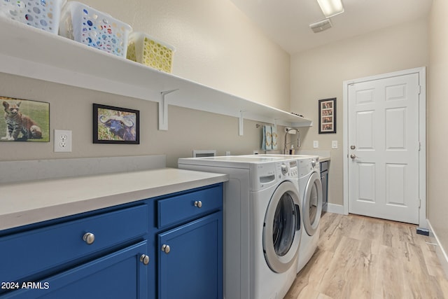 laundry room with cabinets, independent washer and dryer, and light hardwood / wood-style floors