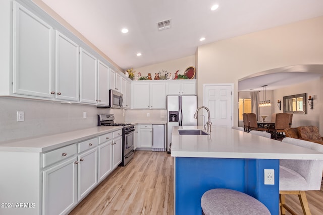 kitchen with lofted ceiling, white cabinets, light hardwood / wood-style flooring, sink, and stainless steel appliances