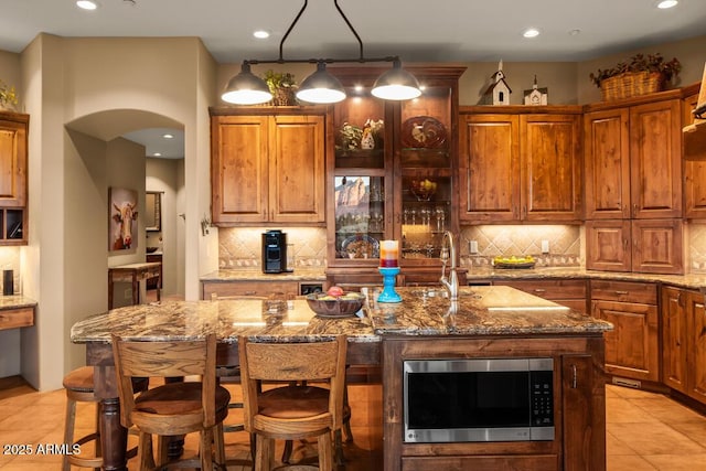 30 Paraiso Corte, Sedona, AZ 86351 - kitchen featuring stainless steel microwave, decorative backsplash, light stone countertops, a breakfast bar area, and recessed lighting