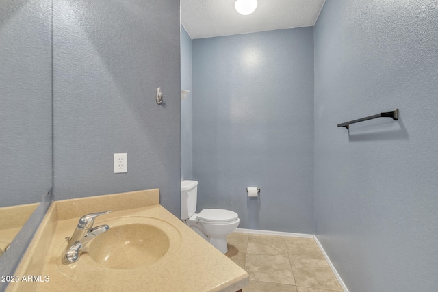 bathroom with tile patterned flooring, vanity, and toilet