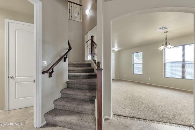 stairs featuring an inviting chandelier and tile patterned floors