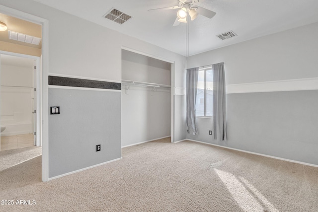 unfurnished bedroom featuring ceiling fan, ensuite bathroom, a closet, and light carpet