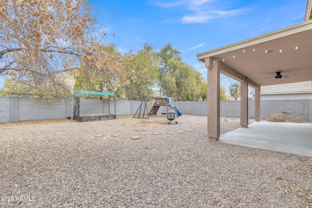 view of yard with a patio area, ceiling fan, and a playground