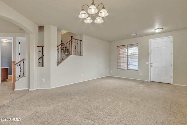 empty room featuring an inviting chandelier and light colored carpet