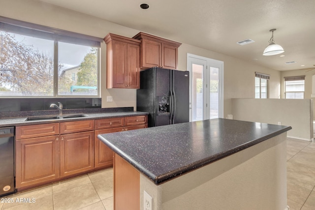 kitchen with sink, light tile patterned floors, black appliances, a kitchen island, and pendant lighting