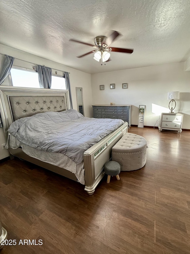 bedroom featuring ceiling fan, dark hardwood / wood-style floors, and a textured ceiling