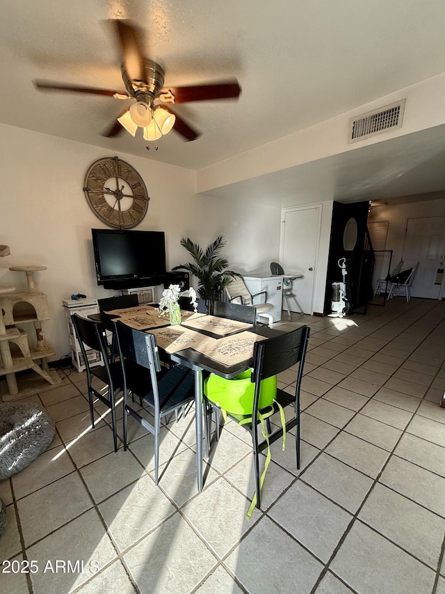 tiled dining area with ceiling fan