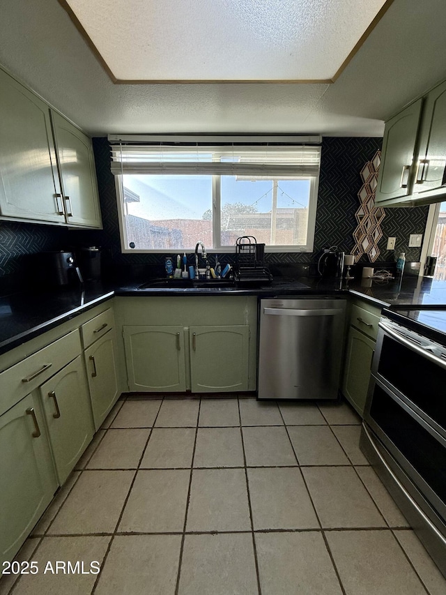 kitchen featuring tasteful backsplash, sink, stainless steel appliances, and green cabinetry