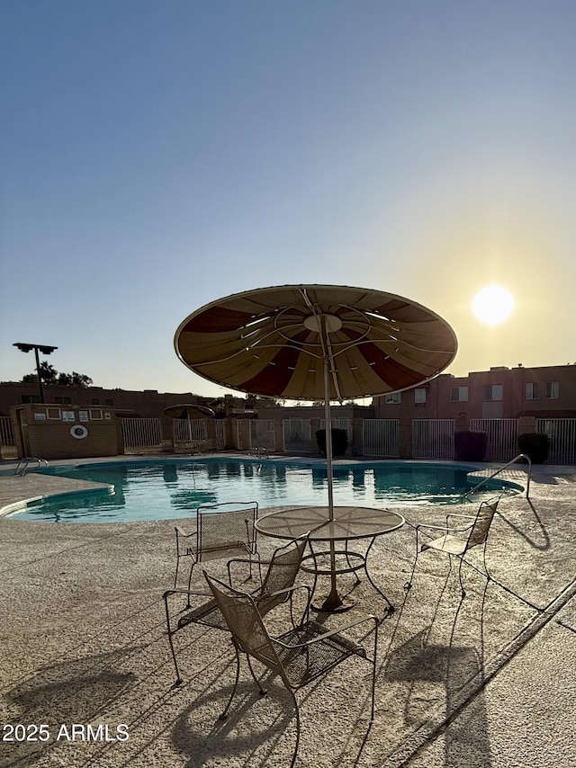 pool at dusk featuring a patio