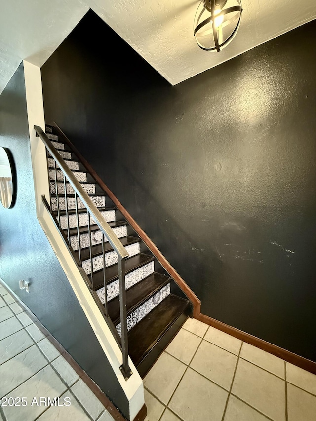 stairs with tile patterned floors and a textured ceiling