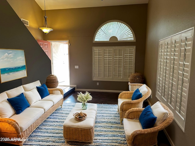 living room featuring visible vents, baseboards, and wood finished floors