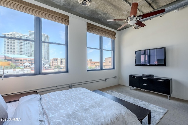 bedroom with a view of city, ceiling fan, and carpet floors