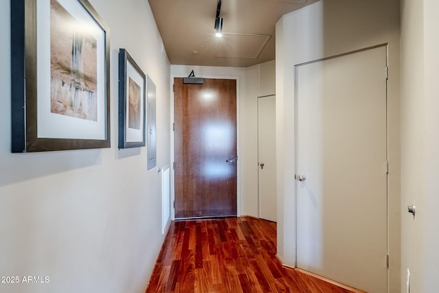corridor featuring attic access and wood finished floors