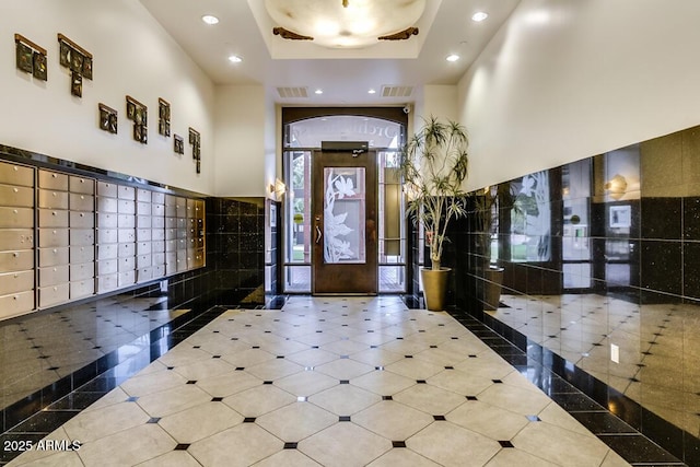 entrance foyer featuring visible vents, a towering ceiling, mail area, and recessed lighting