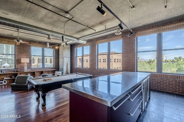 rec room featuring pool table, dark wood-style floors, brick wall, and plenty of natural light