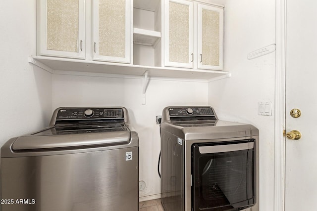 laundry room featuring cabinets and washing machine and clothes dryer