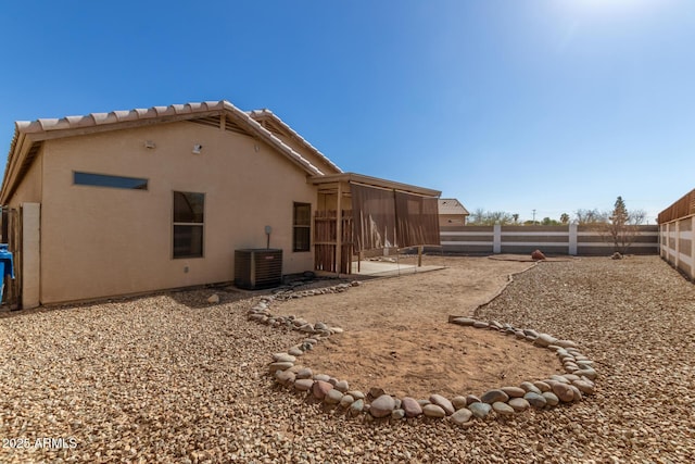 rear view of property featuring central air condition unit and a sunroom