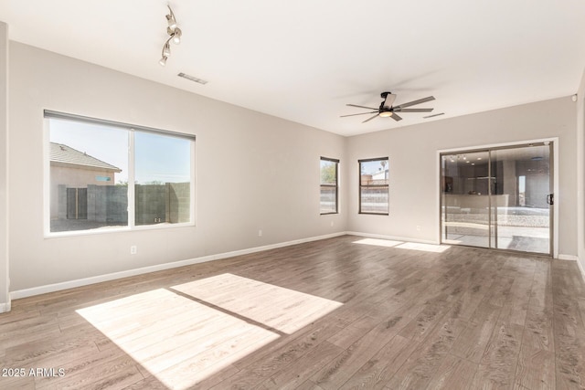 unfurnished room with hardwood / wood-style flooring, a wealth of natural light, and ceiling fan