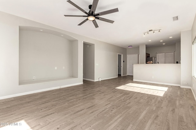 unfurnished living room with ceiling fan and hardwood / wood-style floors