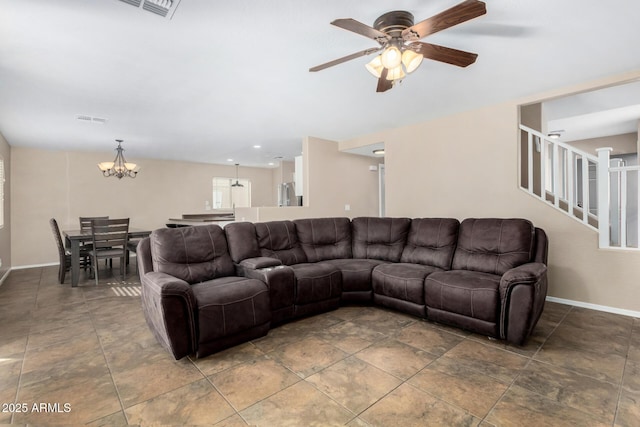 living room featuring ceiling fan with notable chandelier