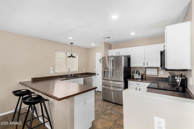 kitchen with sink, appliances with stainless steel finishes, hanging light fixtures, white cabinets, and kitchen peninsula